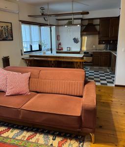 a living room with a brown couch in a kitchen at Pequeno Refúgio in Braga