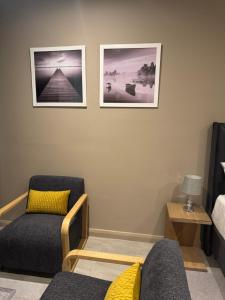 a living room with two chairs and two pictures on the wall at 1128 Executive Studio, The Capital Triology in Pretoria