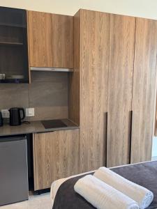 a kitchen with wooden cabinets and a counter top at 1128 Executive Studio, The Capital Triology in Pretoria