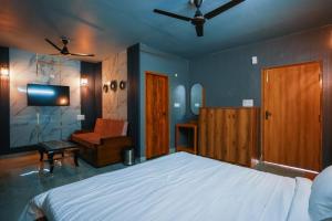 una camera con letto, TV e sedia di Pahadi Aangan - A Boutique Villa By Shivaneel Hospitality a Kota Bāgh