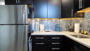 une cuisine avec des armoires noires et un réfrigérateur en acier inoxydable dans l'établissement The Belvedere Unit 2C, à Cape May 11 autres photos