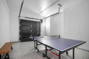a ping pong table in the middle of a room with a ping pong at Full Duplex ATX Modern Creekside Retreat 2 Pools in Austin
