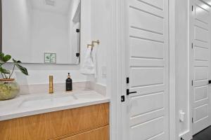 a white bathroom with a sink and a mirror at Full Duplex ATX Modern Creekside Retreat 2 Pools in Austin +58 photos