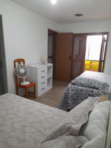 ein Schlafzimmer mit zwei Betten und einer Kommode in der Unterkunft Casa Amarela in Torres