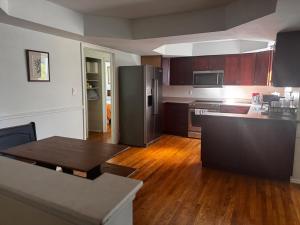 a kitchen with a black refrigerator and a wooden floor at Charming 3-bedroom house in Ann Arbor