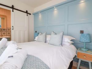 a bedroom with two beds and a blue wall at Beach View House in Newquay