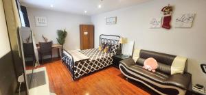 Un dormitorio con una cama, un sofá y un escritorio. en Mainfloor Spacious Room in Toronto, en Toronto