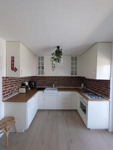 a kitchen with white cabinets and a brick wall at Casa Pax in Horpaz