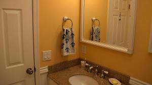 un baño con lavabo y espejo en Sunset Shore House Whole House, en West Cape May 33 fotos más