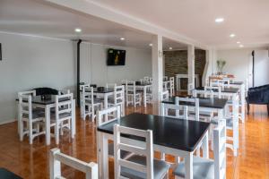 a dining room with tables and white chairs at Hotel Rarinco in Los Ángeles