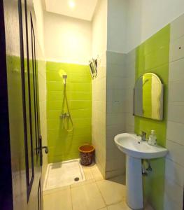 a green bathroom with a sink and a shower at Hassan Apartment - Ideal for Riders, Free Garage Parking Included in Sale +69 photos