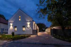 a white house with lights on the side of it at STADIUM HOME Panzió in Németbarnag