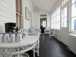 a room with a table and chairs and windows at Victorian On North in Cape May