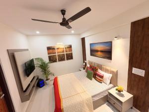 a living room with a bed and a ceiling fan at Couple Canvas- Luxurious 1-BHK Peaceful Apartment in Siroli