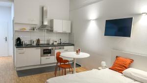 ハイルブロンにあるStylisches Business Apartment nähe Bildungscampus Heilbronnの小さなキッチン(テーブル付)、ベッド1台が備わります。