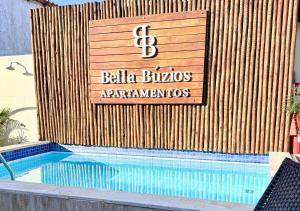 a sign on the side of a swimming pool at Bella Buzios Apartamentos in Búzios