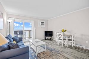 a living room with a couch and a table at Steps to Sand! 3rd-Floor North Topsail Beach Condo in Chadwick Acres