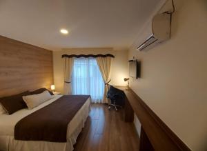 洛斯安赫莱斯Hotel Rarinco的一间带床和窗户的酒店房间