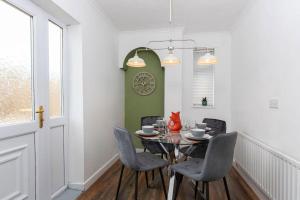 a dining room with a table and chairs and a clock at Park House in Durham