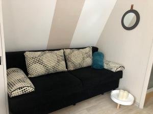 a black couch in a room with a mirror at Rosa-Lila Chalet in Métabief