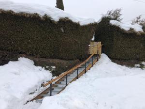 a snow covered staircase with snow on the ground at Rosa-Lila Chalet in Métabief
