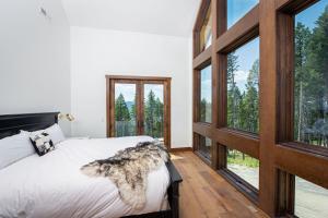 a bedroom with a bed and large windows at Great Northern Mountain Escape in Whitefish