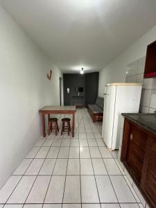 a kitchen with a table and a refrigerator at Hotel e Pousada Recanto do mar in Florianópolis