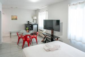 a white room with a table and a tv and a bed at Costa Norte Boutique Hotel Miami Beach in Miami Beach