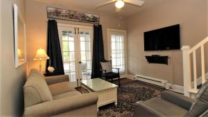 un salon avec un canapé et une télévision dans l'établissement Heritage House 2, à Cape May