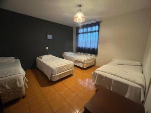 a room with two beds and a window at Hotel e Pousada Recanto do mar in Florianópolis +27 photos