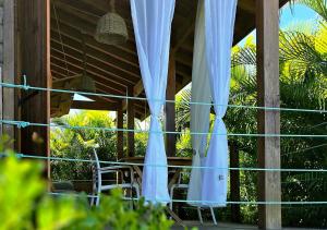 a patio with white curtains and a table and chairs at Hébergement Yucca - Saint-François in Saint-François +4 photos