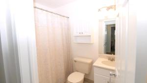 Un baño blanco con inodoro y lavabo. en The Capers 402, en Cape May 10 fotos más