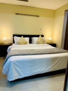 a bedroom with a large bed with white sheets and pillows at Centaurus Services apartment, luxury studio apartment in Islamabad