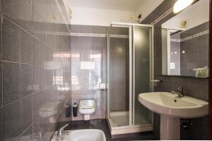 a bathroom with a sink and a shower and a toilet at Cavallo Bianco in Chivasso +7 photos