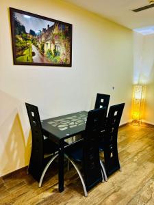 a dining room table with chairs and a painting on the wall at Centaurus Services apartment, luxury studio apartment in Islamabad +2 photos