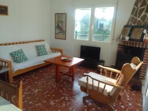 a living room with a couch and a table at Chalet Maria con Jardín Mediterráneo in San Juan de Alicante