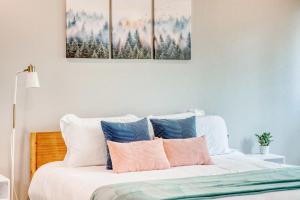 a bedroom with a bed with four paintings on the wall at Bike-Friendly Retreat with Fenced Yard & Trails in Dug Hill