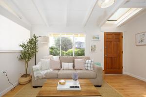 un salon avec un canapé et une table dans l'établissement Private Cottage House - Walk to Beaches HarborFood Trials so much more, à El Granada