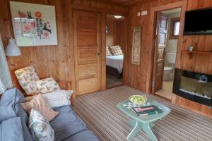 a living room with a couch and a table at 10 Pinewood Retreat in Lyme Regis