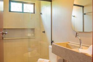 een badkamer met douche, wastafel en spiegel bij Sol&coqueiros in Pôrto de Pedras +6 foto's