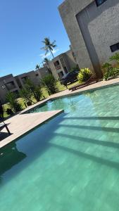 een zwembad met helderblauw water voor een gebouw bij Sol&coqueiros in Pôrto de Pedras