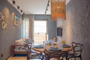 een eetkamer met een houten tafel en stoelen bij Sol&coqueiros in Pôrto de Pedras