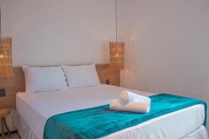 een pop zit bovenop een bed bij Sol&coqueiros in Pôrto de Pedras