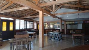 a room with wooden tables and chairs in a building at Super Flats Geribá in Búzios