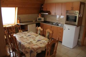 a kitchen with a table and a kitchen with a stove at u Andrása in Veľký Meder