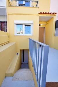 a staircase leading up to a yellow building with a window at MBird Casa Limão Hideaway Cascais in Bicas