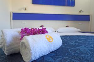 a hotel room with towels and flowers on a bed at Podere San Luigi Residence in Otranto