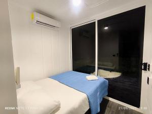 Una pequeña habitación con una cama y una ventana. en Tucan container, en Tapantí