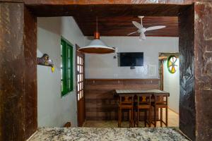 a kitchen with a table and a ceiling fan at Villa do Portinho - Casas em frente à Praia in Ilhabela