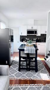 a kitchen with a black table and a refrigerator at Chic City Guesthouse Getaway in Riverside